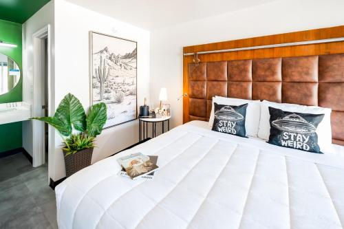 a bedroom with a large white bed with a wooden headboard at Heights House Hotel - Houston Heights Downtown, an Ascend Collection Hotel in Houston