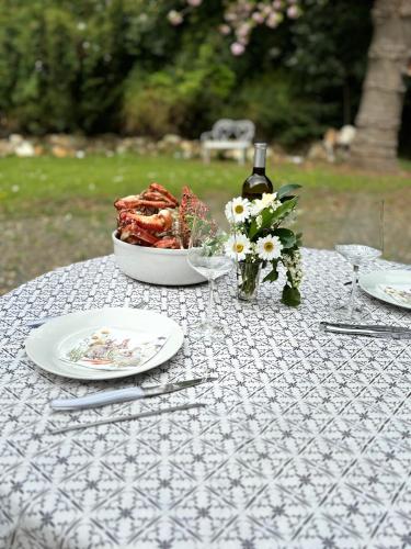 a table with a plate of food and a bottle of wine at Le vieux clos du rucher kêr-melen in Paimpol