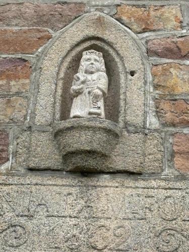 a stone statue on the side of a building at Le vieux clos du rucher kêr-melen in Paimpol