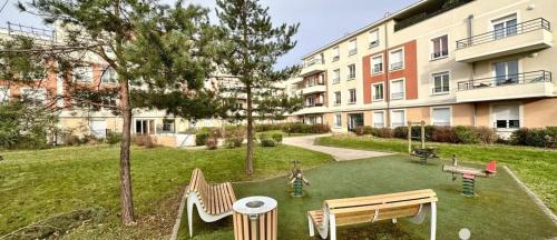 une cour avec une aire de jeux en face d'un bâtiment dans l'établissement chambre d'ami chez Raissa, à Trappes