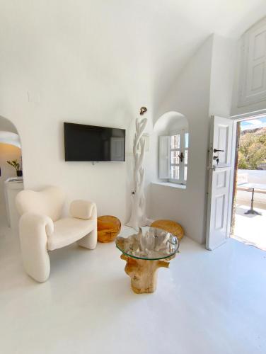 a living room with a tv and a couch and a table at The Magic Luxury Cave Suites in Vóthon