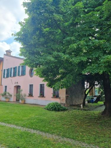 a large tree in front of a house at Agriturismo Case in Collina in Volta Mantovana