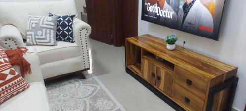a living room with a couch and a tv at Serene BnB - Apt 01 Makongo after Mlimani City in Dar es Salaam