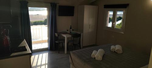 a hotel room with a bed and a balcony at Anna's Apartments and Studios - Planespotter's Paradise!!! in Corfu Town