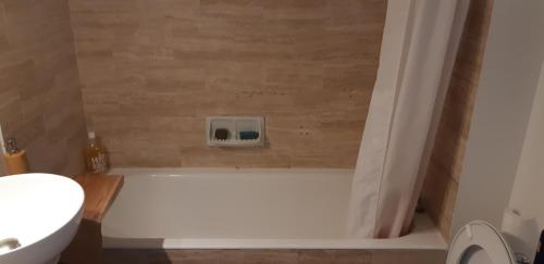 La salle de bains est pourvue d'une baignoire avec une horloge murale. dans l'établissement Agréable studio 2-4 personnes à Mandelieu, à Mandelieu-la-Napoule