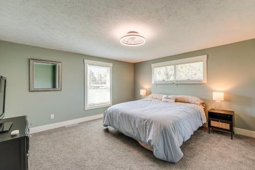 a bedroom with a bed and two windows at Less Than 3 Mi to Double JJ Resort Home with Large Yard! in Rothbury