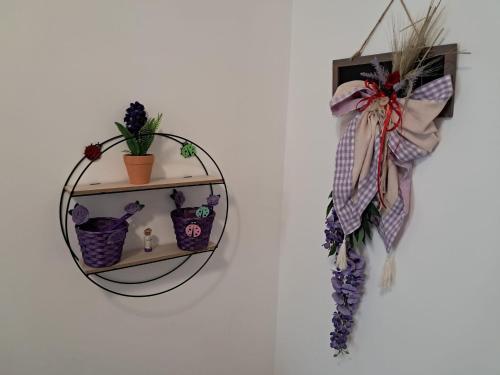 a mirror hanging on a wall with flowers and plants at NORA House in Savona
