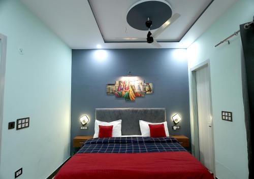 a bedroom with a red bed with two red pillows at VMP Villa Home Stay in Tājganj