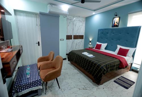 a bedroom with a bed and a chair and a desk at VMP Villa Home Stay in Tājganj
