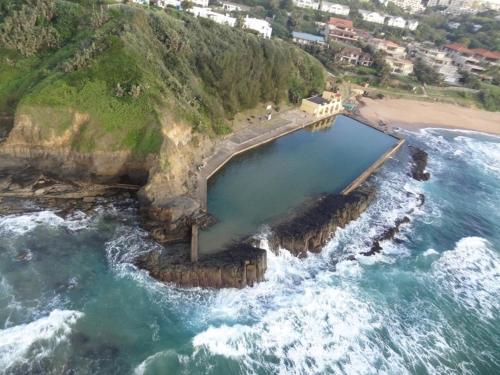 an aerial view of a body of water next to a beach at Chakas Rock Chalet 57 in Ballito