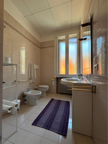 a bathroom with a sink and a toilet and a window at Giove Rooms in Verona
