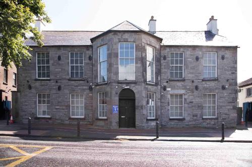 an old stone building with a door on a street at The Duke Maynooth in Maynooth