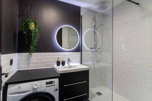 une salle de bain avec un lavabo et une machine à laver dans l'établissement Comfort and style close to Disney, à Chessy