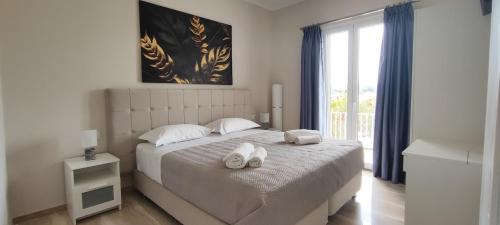 a bedroom with a bed with two towels on it at Anna's Apartments and Studios - Planespotter's Paradise!!! in Corfu Town