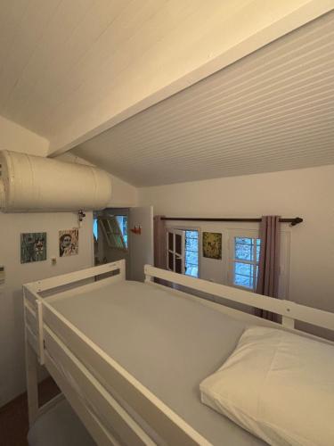 un lit blanc dans une chambre avec une fenêtre dans l'établissement Maison vue mer 4 chambres - 7 min plage, à Cavalaire-sur-Mer