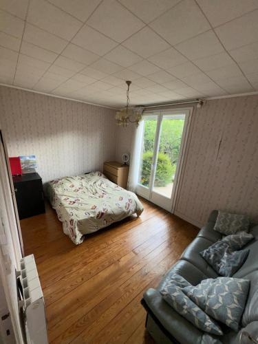 une chambre avec un lit, un canapé et une fenêtre dans l'établissement Logement entier, à Nemours