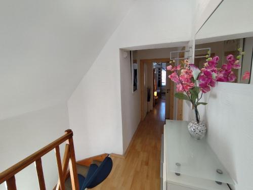a room with a vase with pink flowers in it at Ferienwohnung Daun in Daun