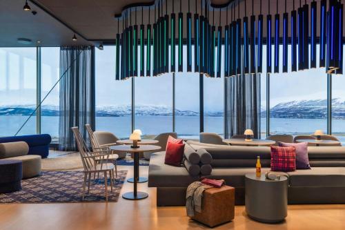 a hotel lobby with a view of the water and mountains at Moxy Tromso in Tromsø
