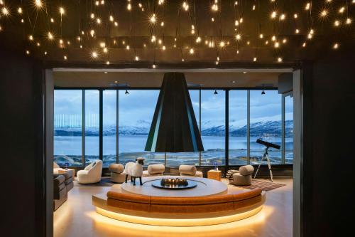 a living room with a fireplace and a large window at Moxy Tromso in Tromsø
