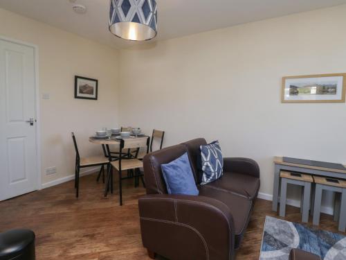 a living room with a couch and a table at Eve's Attic in Bowness-on-Windermere