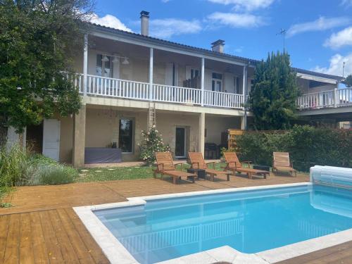 a house with a swimming pool in front of a house at L entre cœur des deux mers in Cadillac