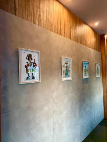 a wall with four pictures on a wall at Hotel SPA GBC Arcade in Arcade