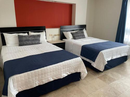 a bedroom with two beds with blue and white at Hotel Empresarial in Paraíso