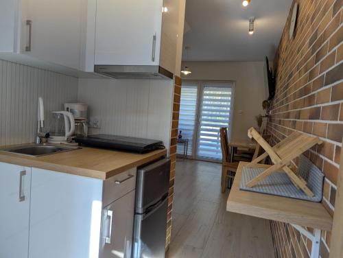 a kitchen with a counter and a brick wall at Extra Apartament Leśny Miodek Sielpia Wielka in Sielpia Wielka