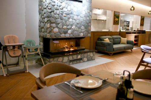 a living room with a fireplace and a table and chairs at Valbona River Hotel in Jah Salih