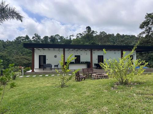 a small white house with a grass yard at Casa de la Cascada in Pedro Vicente Maldonado