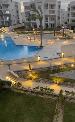 a courtyard with a pool in a building with lights at Amwaji in El Alamein
