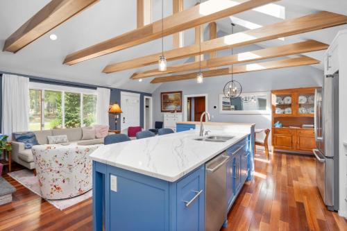 a kitchen with blue cabinets and a living room at 18 Bourne Avenue Sandwich - - Cape Cod in East Sandwich