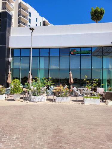 a building with tables and umbrellas in front of it at Walk To Mall, Chic Decor 1br! Near Ferrari, F1 in Abu Dhabi