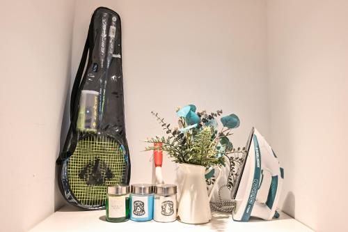 a shelf with a bag and a vase with a plant at Walk To Mall, Chic Decor 1br! Near Ferrari, F1 in Abu Dhabi