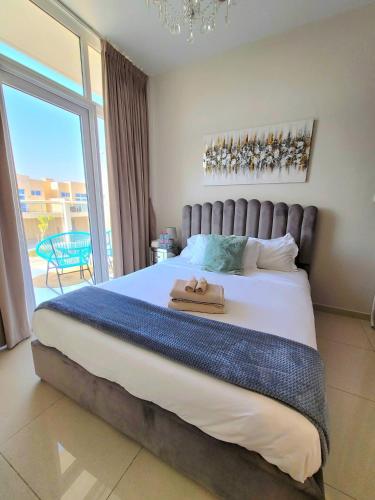 a bedroom with a large bed with a large window at Damac Hills 2 Villa Pool Front + Waterpark Access in ‘Ūd al Bayḑāʼ