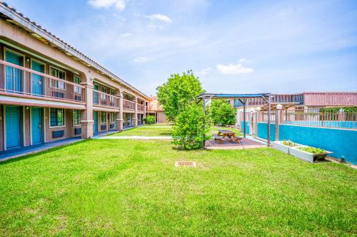 a large yard in front of a building at Lone Star Inn & Suites by OYO Harlingen TX in Harlingen