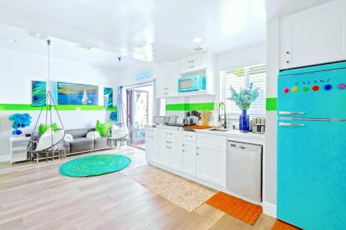 a kitchen with white cabinets and a blue refrigerator at D- Hip NoHo Haven Hot Tub - Family - Parking in North Hollywood