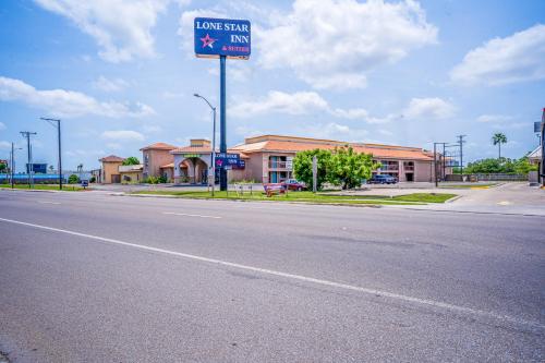 a sign for a low star inn on the side of a road at Lone Star Inn & Suites by OYO Harlingen TX in Harlingen