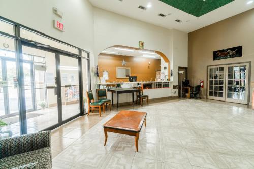 a lobby with a table and chairs in a building at Lone Star Inn & Suites by OYO Harlingen TX in Harlingen