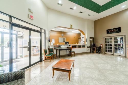 a lobby with a table and chairs in a building at Lone Star Inn & Suites by OYO Harlingen TX in Harlingen