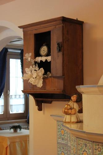 a wooden cabinet with a clock on a wall at Meublè Cima Bianca Garni in Bormio