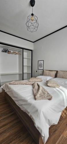 a bedroom with a large bed with white sheets at Black and white suites 2 in Thessaloniki