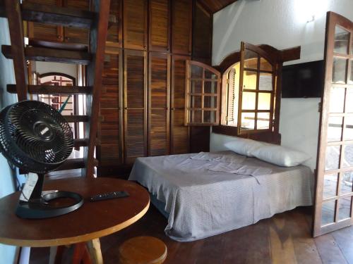 a bedroom with a bed and a fan on a table at Residencial Villa Cantareira in Caieiras