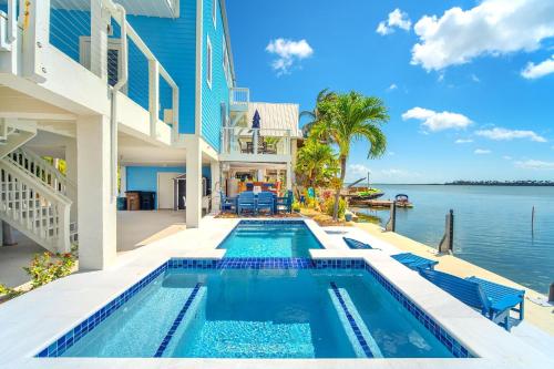 a swimming pool in front of a house with the water at Into the Blues in Bay Point