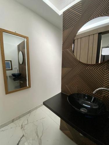 a bathroom with a black sink and a mirror at El Solar Casa Hotel in Manizales