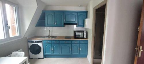 une cuisine avec des armoires bleues et une machine à laver dans l'établissement Apartment Julia - Parking gratuit, Gare de Tours et St-Pierre-des-Corps TGV & Parc Expo, à Tours