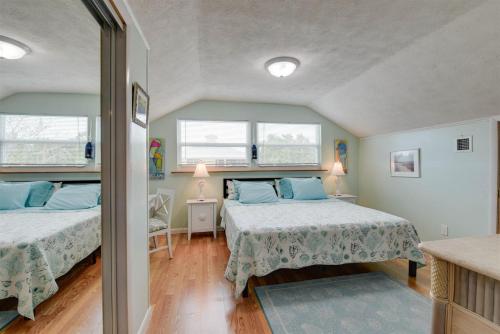 two beds in a room with two windows at Casa de Sueno in Summerland Key