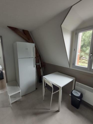 Il comprend une cuisine équipée d'une table blanche et d'un réfrigérateur. dans l'établissement Apartment Julia - Parking gratuit, Gare de Tours et St-Pierre-des-Corps TGV & Parc Expo, à Tours