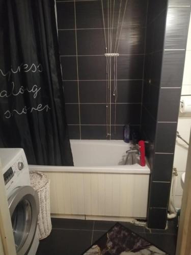 a bathroom with a tub and a sink and a washing machine at Apartamenty na doby in Siedlce