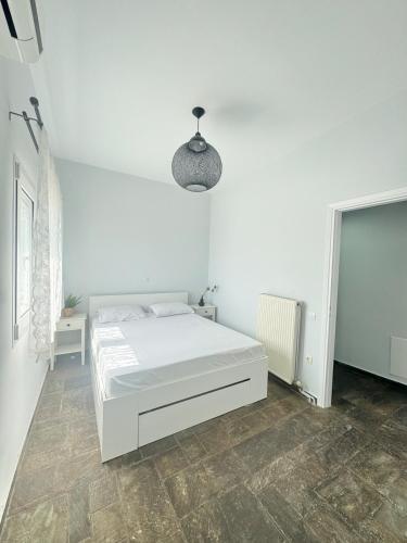 a white bedroom with a white bed and a lamp at Beachfront ! in Amarynthos